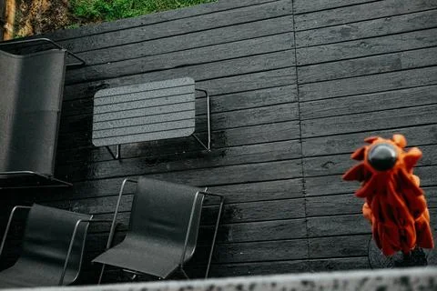 Overhead view of a backyard scene featuring a grill on a wet deck. A backyard Stock Photos