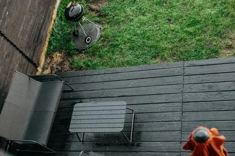 Overhead view of a backyard scene featuring a grill on a wet deck. A backyard Stock Photos