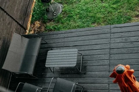 Overhead view of a backyard scene featuring a grill on a wet deck. A backyard Stock Photos