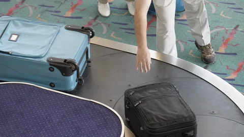 Overhead View of Baggage Carousel with Multiple Travelers Claiming Luggage Stock Footage 124767563