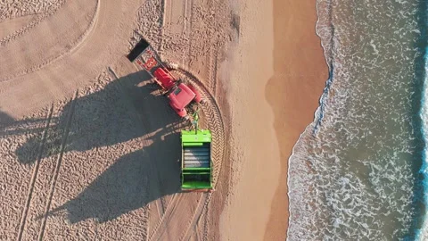 Overhead view of beach cleanup at sunrise, with a tractor and trailer colle.. Stock-Footage 283973257