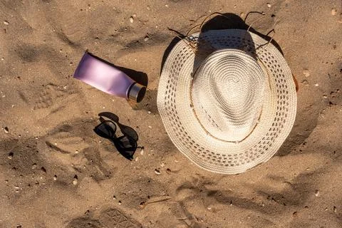 Overhead view of beach essentials layout featuring a woven straw hat black su Stock-Fotos
