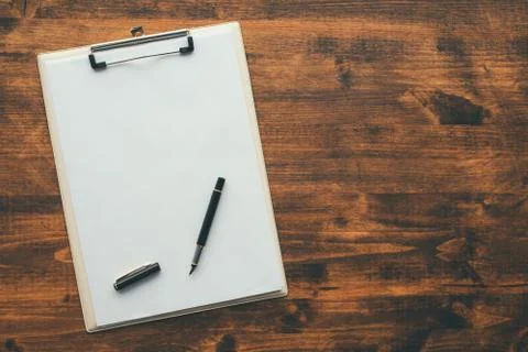 Overhead view of blank clipboard note pad paper with pen Stock Photos