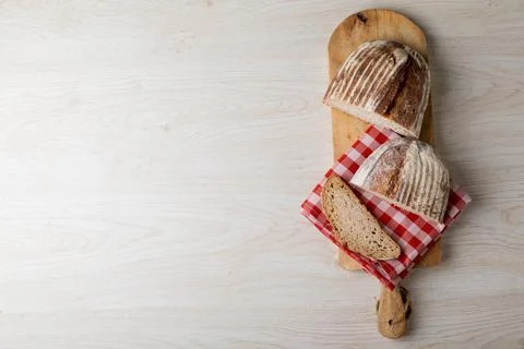 Overhead view of bread with checked pattern napkin on serving board at table Stock Photos