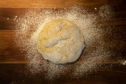 Overhead view of bread dough ball on a wooden cutting board with flour. Stock Photos
