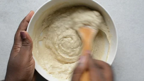Overhead view of brown hand stirring batter Stock Footage 274946876