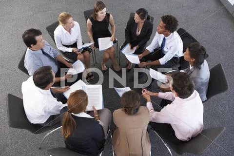 Overhead View Of Businesspeople Seated In Circle At Company Seminar Stock-Fotos