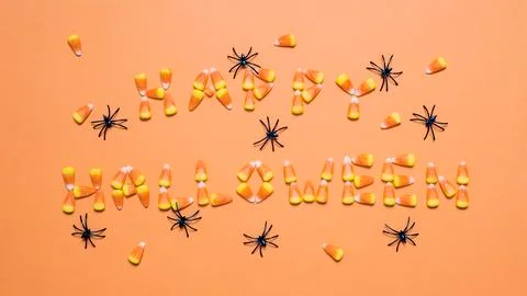Overhead view of candy corns arranged as Happy Halloween text amidst artificial Stock Photos
