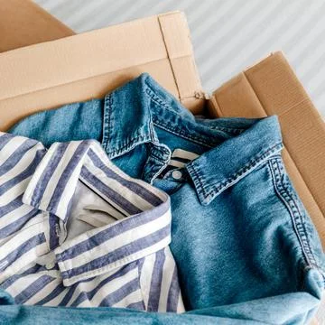 Overhead view at card box with clothes inside. Stock Photos