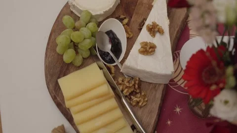 Overhead View of Cheese Platter with Grapes, Walnuts, and Jam on Festive Table Stock Footage 342279528