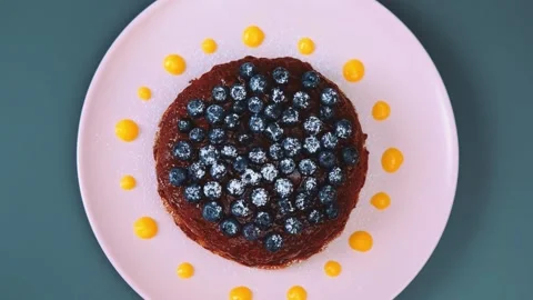 Overhead view of chocolate blueberry cake on pink plate indoors Vidéo 342863050