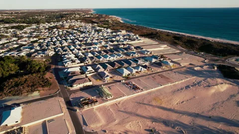 Overhead view of a coastal residential development near a sandy beach Stock Footage 303079638