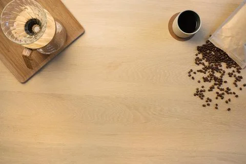 Overhead view of coffee beans with cup and filtration containers on table Stock Photos
