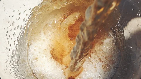 Overhead View of Cold Beer Pouring from Bottle into Glass Mug with Foam Stock Footage 342970139