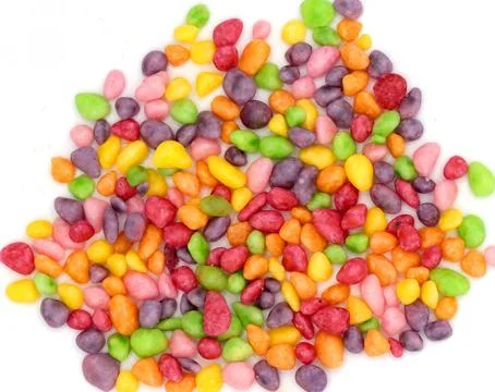 Overhead view of colorful irregular candy pebbles scattered on white backgrou Stock-Fotos