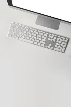 Overhead view computer with blank screen and wireless keyboard on white table. Stock Photos