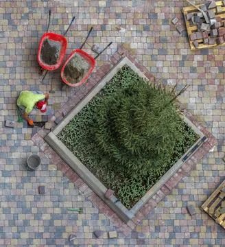 Overhead view of a construction worker laying interlocking paving stones. Stock Photos