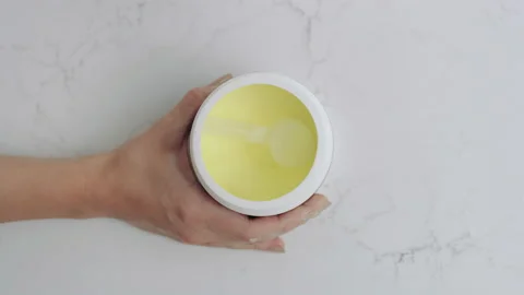 Overhead view, container of yellow drink powder opened, scooped slow motion 스톡 동영상 193762630