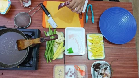 Overhead view of cook patting raw beef steak dry with paper towels on cutting Stock Footage 345376814