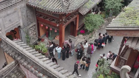 Overhead view of crowd of visitors walking through Chinese temple courtyard in Stock Footage 333150359