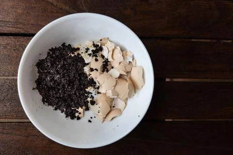Overhead view of crushed egg shell and spent coffee grounds in bowl. Natural Stock Photos