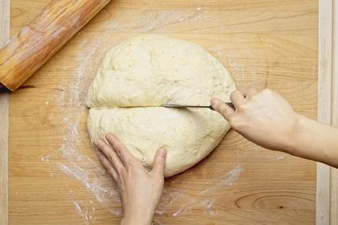 Overhead view of cutting dough in half. Stock Photos
