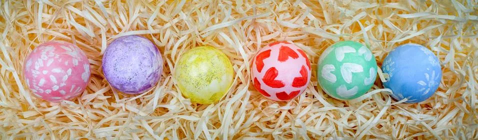 Overhead view of decorated Easter eggs lined up in a row over a background of Stock Photos