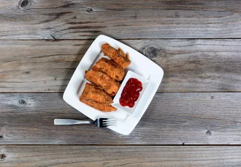 Overhead view of deep fried fish in plate on rustic wooden table Stock-Fotos