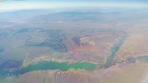 Overhead view of a desert region intersected by a vibrant green river in 4k.. Stock Footage 281256912
