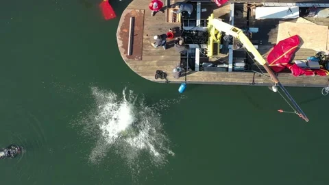 Overhead View Of Diver Jumping Into The Water Prior To Sunken Boat Recovery. 4K Stock Footage 152423298