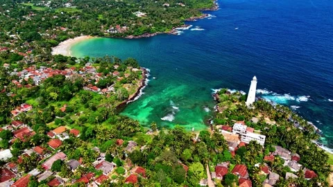 An overhead view of Dondra Head reveals vibrant turquoise waters, lush Stock Footage 330867174