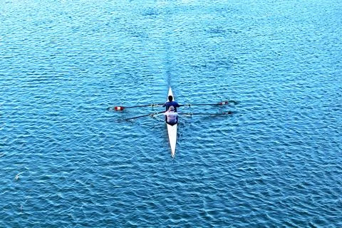 Overhead view of a double scull rowing team on calm blue rippled water Photos