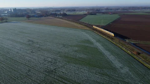 Overhead View of Dutch Train Traversing Frozen Meadow Stock Footage 241116068