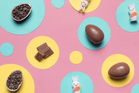 Overhead view easter eggs rabbit choco chips round frame pink background Stock Photos