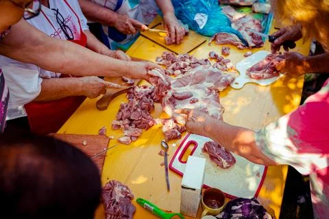 Overhead view on elderly man and several women are cutting are cutting meat Stock Photos