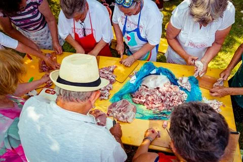 Overhead view on elderly man and several women are cutting are cutting meat Stock Photos