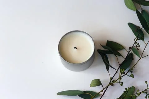 Overhead View of Eucalyptus Branches Next to a White Soy Candle Stockfoto's