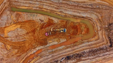 Overhead view of excavator digging in sand quarry. Top down drone shot of yellow Stock Footage 336483748