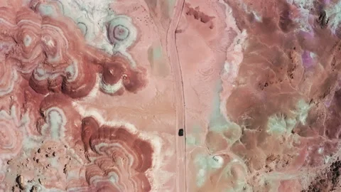 Overhead view expensive luxury SUV car driving by red dusty road colorful hills 스톡 동영상 165638563