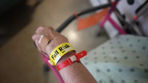 Overhead view of Fall Risk wristband bracelet on an elderly persons arm in a 스톡 동영상 286344492