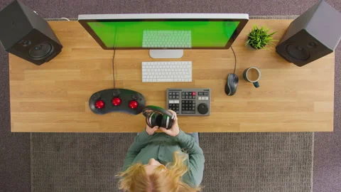 Overhead View Of Female Video Editor Working At Computer With Green Screen In Stock Footage 168890315