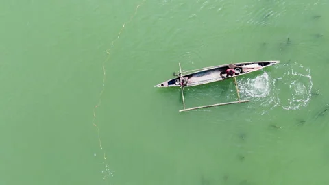 Overhead view of fishermen working with a cast net and an underwater raft in the Stock Footage 336692514