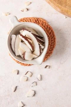 Overhead view of fresh sliced coconut pieces in a small white ceramic bowl .. Stock Photos