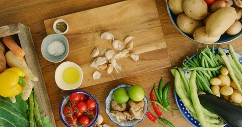Overhead View Of Garlic Cloves On Cutting Board By Various Vegetables In Kitchen Video stock 92181933