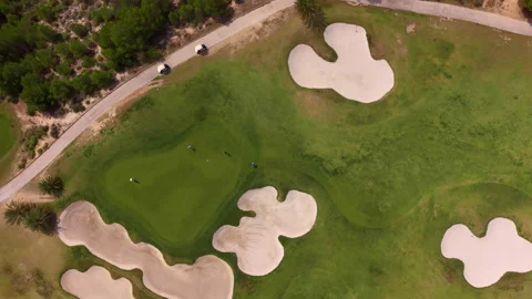 Overhead view of a golf course green surrounded by multiple sand bunkers, with Stock Footage 334785297