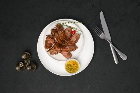 Overhead view of grilled rack of lamb on a plate with spicy sauce 스톡 사진