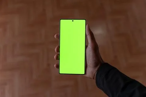 Overhead View of Hand Holding Smart phone with Green Screen Mockup Chroma Key. Fotos de archivo
