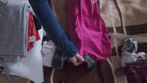 Overhead View of Hands Folding Bright Garments Stock Footage 327854008