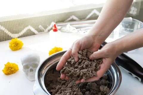 Overhead view of hands kneading clay in a metal bowl to craft a decorative Da Stock Photos