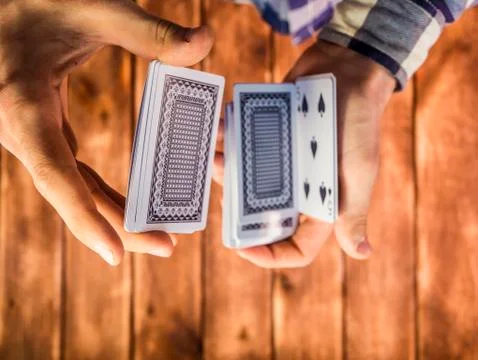 Overhead view of hands mixing playing cards on the wooden surface Stock Photos